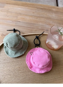 Close-up of mini fisherman hat coin pouches in green and pink corduroy with heart zippers