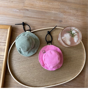 Detail view of mini corduroy hat pouches in green and pink with heart zippers