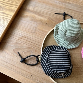 Detail of mini hat pouches with heart zipper and corduroy texture on wood tray