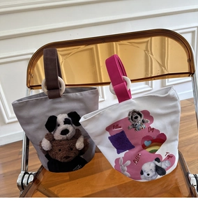 Dettaglio di borse tote in tela con manici ad anello in legno e decori di peluche 3D