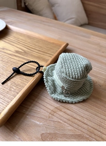 Detailed view of mint green corduroy mini bucket hat bag with heart zipper on wooden tray
