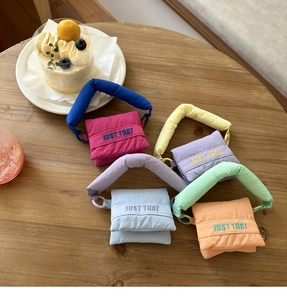 Close-up of quilted mini earphone bags in vibrant macaron colors with embroidery
