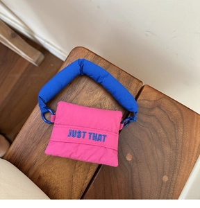 Close-up of puffy pink and blue nylon storage bag with blue 'JUST THAT' embroidery
