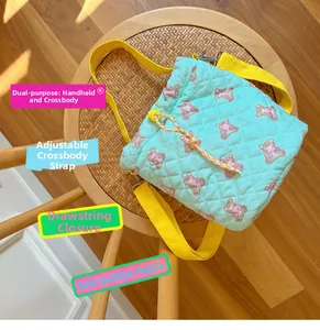 Detail of mint green quilted drawstring bag with pink bear print and yellow strap