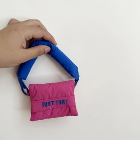 Close-up of a quilted puffy mini handbag with contrast blue and pink colors and embroidery