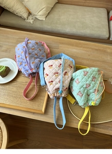 Close-up of quilted bucket bags in macaron colors with cute bear and cherry patterns