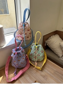 Detailed macro view of quilted cotton bucket bags featuring cute cherry and bear prints