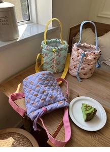 Detailed close-up of quilted macaron candy color bucket bags with bear patterns