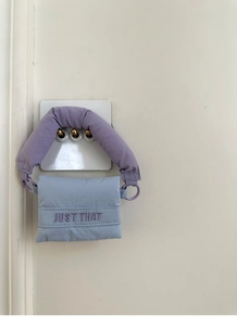 Detail of light blue puffy mini bag with purple Just That embroidery and thick handle