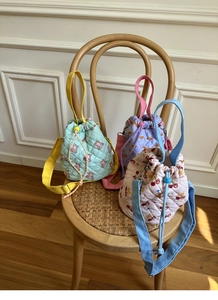 Quilted bucket bags with cute bear patterns in macaron colors on a wooden chair