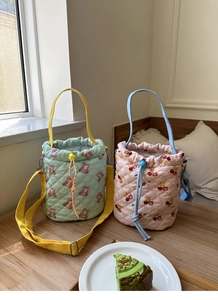 Quilted bucket bag detail showing mint bear and pink cherry patterns with drawstrings