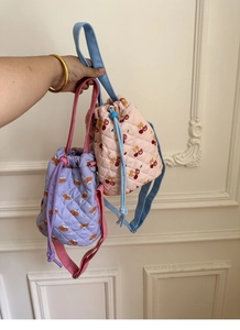 Close-up of quilted bucket bags with cute bear patterns and colorful fabric straps