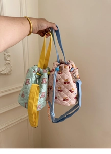 Detail of cute quilted drawstring bucket bags with bear patterns and colorful straps