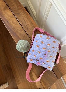 Close-up of lavender quilted bucket bag with brown bear prints and drawstring closure