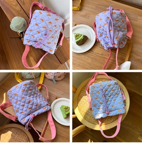 Detail view of quilted lavender bucket bag with brown bear patterns and pink strap