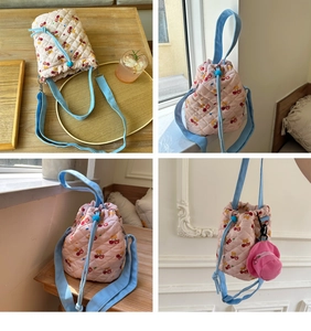 Detail of pink quilted bucket bag featuring cherry bear prints and blue drawstring closure