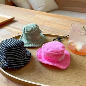 Mini fisherman hat pouches in various colors and corduroy textures on a wooden tray