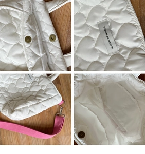 Detail of white quilted heart tote with magnetic clasp, pink straps and interior pocket