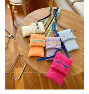 Detailed top view of colorful nylon mini crossbody bags with Just That embroidery