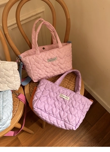Close-up of heart quilted fabric textures and colorful crossbody straps on fashion bags