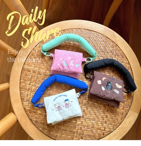 Close-up of three colorful quilted mini animal crossbody bags on a woven chair