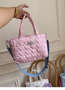 Detail of pink quilted heart tote bag with blue strap and 'You Are So Fashion' label