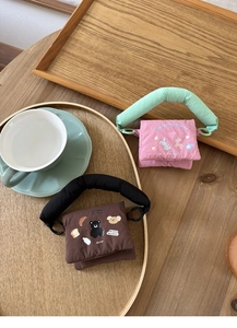 Quilted mini pouches in pink and brown with cute animal patterns on a wooden tray