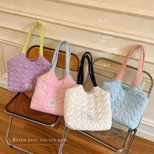 Quilted canvas tote bags with heart patterns in pastel colors on transparent chairs