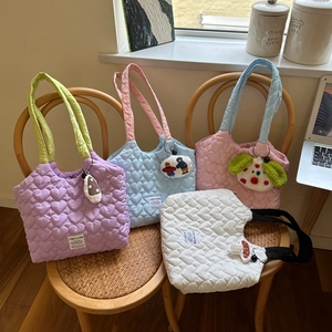 Detailed heart quilted design on colorful canvas tote bags in a cozy home setting