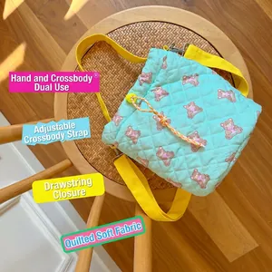 Quilted mint green bucket bag with purple bear pattern and adjustable yellow strap