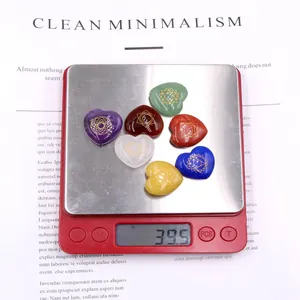 Weight measurement of 7 colorful chakra heart stones with golden symbols on a digital scale