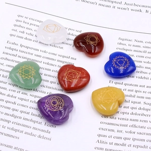 Seven chakra healing crystal set with heart-shaped engraved natural stones on vintage book