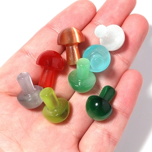 Colorful mini cat eye stone mushroom figurines for garden decor held in palm