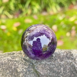 Natural 25mm purple amethyst crystal ball with polished finish on a stone pedestal