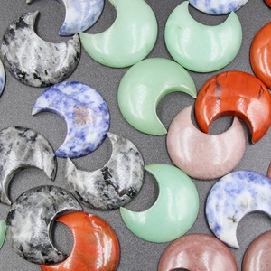 Variety of polished natural stone crescent moons including rose quartz and aventurine