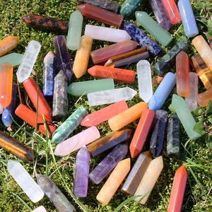 Natural hexagonal crystal points in various gemstones on a green moss background
