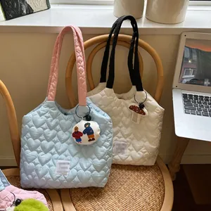 Close-up of heart-shaped quilted canvas tote bags with colorful mushroom charms