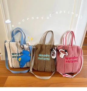 Three lamb wool tote bags in white, brown, and pink with wonder natural embroidery detail