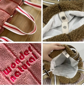 Detail of wool-like fleece tote bag showing red wonder embroidery and striped webbing straps