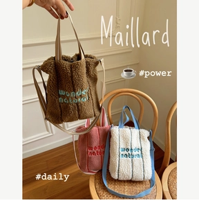 Detailed embroidery on fuzzy lambswool tote bags in brown, pink and white colors