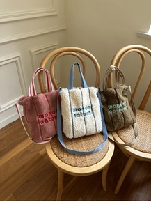 Detailed view of plush fleece tote bags with wonder embroidery in three cozy colors