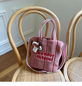 Pink sherpa tote bag detail with red wonder natural embroidery and mushroom charm