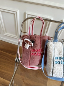 Detail of lamb wool tote bags with wonder nature embroidery and mushroom pendants