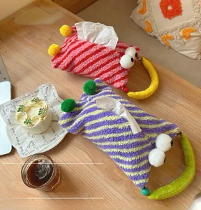 Detail of colorful striped plush car tissue holders with quirky large eye decorations