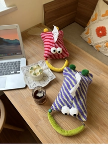 Detail of striped plush tissue holders with cute 3D eyes and soft ball decorations