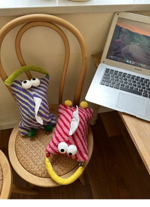 Close-up of creative striped plush tissue holder with big eyes on a vintage chair