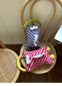 Detail of colorful striped plush monster tissue box covers with handles and eyes