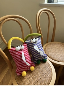 Detail showing plush monster tissue boxes with fluffy fur and cute eyes on a vintage chair
