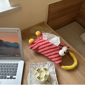 Close-up of pink and red striped plush tissue box cover with a banana-shaped handle