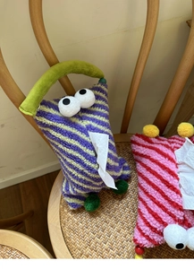 Close-up of cute plush monster tissue box with fuzzy texture and funny eyes for car interior